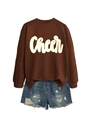 Detail eines braunen Sweatshirts mit gelbem Cheer-Schriftzug und Denim-Shorts - Kaffeebraun
