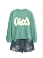 Flachbild-Set aus minzgrünem Cheer-Sweatshirt und destroyed Denim-Shorts auf weißem Hintergrund - Hellgrün