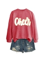 Detail von rotem Sweatshirt mit weißem Cheer-Schriftzug und abgenutzten Denim-Shorts - Rot