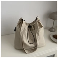 Detalle del bolso de nailon beige con cordón ajustable y prácticos bolsillos laterales - Caqui