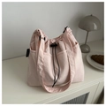 Detalle del bolso tote de nailon rosa claro con cierre de cordón y etiqueta de marca - Rosa