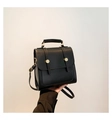 Details der schwarzen matten Ledertasche mit goldenen Metallschnallen und Tragegriff - Schwarz