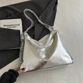 Silver metallic bucket bag with embossed logo and chain strap on a grey blazer - Silver Large