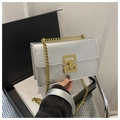 Close-up of silver chain bag featuring a gold geometric lock and sleek metallic finish - Silver