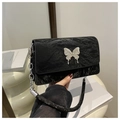 Detail of black pleated shoulder bag with silver butterfly charm and chain strap - Black