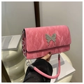Detailed macro view of pink pleated shoulder bag with silver butterfly metal buckle - Rose Pink