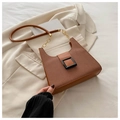 Detail of a brown patchwork handbag with woven texture and a black resin buckle on a blazer - Brown