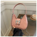 Pink hobo bag with silver metal bow clasp and chain strap in a lifestyle tea setting - Pink