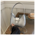 Close-up of silver metallic crescent bag with bow buckle and chain strap detail - Silver