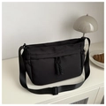 Close-up of black Oxford cloth shoulder bag featuring decorative woven drawstring details - Black