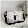 Detail of white nylon shoulder bag featuring black drawstring and wide crossbody strap - White