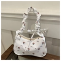 Dettaglio borsa in tela floreale con tracolla a ruche e fiocco decorativo applicato - Bianco