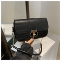 Detail of black crocodile-embossed leather handbag featuring a gold metallic clasp and chain - Black