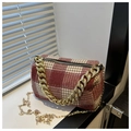Detalle de bolso cilíndrico de cuadros rojos con cadena dorada y tejido de lana - Grandes Cuadros Rojos