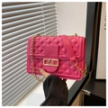 Detail der rosaroten Stepptasche mit goldener V-Schnalle und Metallkettenriemen - Rosenrosa
