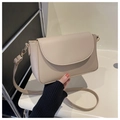 Detail of a beige faux leather crossbody bag with curved flap and adjustable strap - Khaki