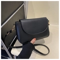 Detailed close-up of a black matte leather shoulder bag with gold metal hardware - Black