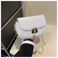 Detail of white leather saddle bag showing gold oval twist lock and chain strap - White