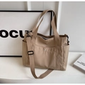 Detail view of khaki nylon tote bag featuring front snap pocket and adjustable strap - Khaki