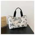 Detalle del bolso tipo cubo blanco con estampados de mariposas negras y asas de cuero - Negro