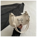 Primer plano del bolso de cuero blanco con detalle de mariposa metálica y asa con nudos - Blanco