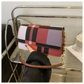 Détail d'un sac sous le bras à carreaux rouges et noirs avec chaîne dorée - Rouge