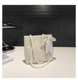 Dettaglio della borsa tote in paglia intrecciata con manici in corda e foulard di seta - Bianco Sporco