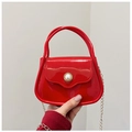 Detail of red jelly bag with glossy finish and pearl embellished gold buckle strap - Red