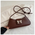 Detail of a brown leather shoulder bag featuring a silver butterfly buckle and slim strap - Brown
