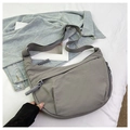 Detail view of grey nylon dumpling bag with adjustable wide strap and woven zipper pull - Gray