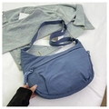Detail of blue nylon crescent bag showing crinkled fabric and adjustable wide strap - Blue
