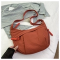 Detail of orange nylon crescent bag featuring a braided rope zipper puller and wide strap - Orange