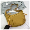Detail of mustard yellow nylon crossbody bag featuring handmade woven knot zip pulls - Yellow