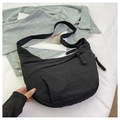 Detail of black nylon dumpling bag featuring woven zipper pull and wide strap - Black