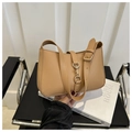 Close-up of beige leather underarm bag with gold metal buckle and adjustable shoulder strap - Khaki