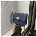 Détail du denim matelassé et de la chaîne dorée sur un petit sac carré élégant - Bleu foncé