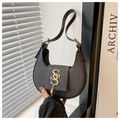 Detail einer schwarzen Halbmond-Schultertasche mit goldener S-Schließe und Quasten - Schwarz