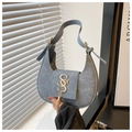 Détail macro du sac demi-lune en denim avec fermoir doré SS et pompon à franges chic - Bleu clair