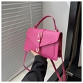 Détail du sac bandoulière en cuir rose avec une boucle métallique dorée en fer à cheval - Rose rose