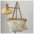 Detalle del bolso tote blanco con estampado de mariposas y asas de cuero amarillo - Caqui