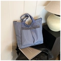 Détail du cabas en nylon bleu-gris avec poches avant fonctionnelles dans un décor chic - Bleu Brume