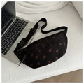 Detail of black corduroy saddle bag with strawberry print on a white sofa next to laptop - Black