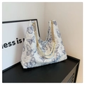 Detail of blue butterfly embroidery on white textured fabric of a large chain tote bag - Blue