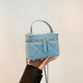 Bolso cilíndrico azul claro acolchado con correa de cadena dorada y asa de mano sup. - Azul