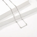 Collana minimalista in argento con barre geometriche su un piedistallo bianco - Stile Bar Geometrico Minimalista (T0130)