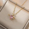 Rosafarbene Herz-Planeten-Halskette mit Goldkette und Diamanten in einer Schmuckschatulle - Goldene Rosa Planeten Halskette