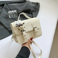 Elegante bolso bandolera color crema con hebillas dobles y un lindo colgante infantil - Blanco con colgante