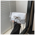 Detail view of silver crossbody bag with crystal bow and metallic chain strap - Silver