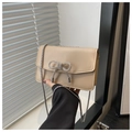 Detail of beige flap bag featuring a rhinestone bow buckle and silver chain strap - Khaki