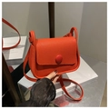 Detail of bright orange pebble grain leather bag featuring a round matching buckle - Red